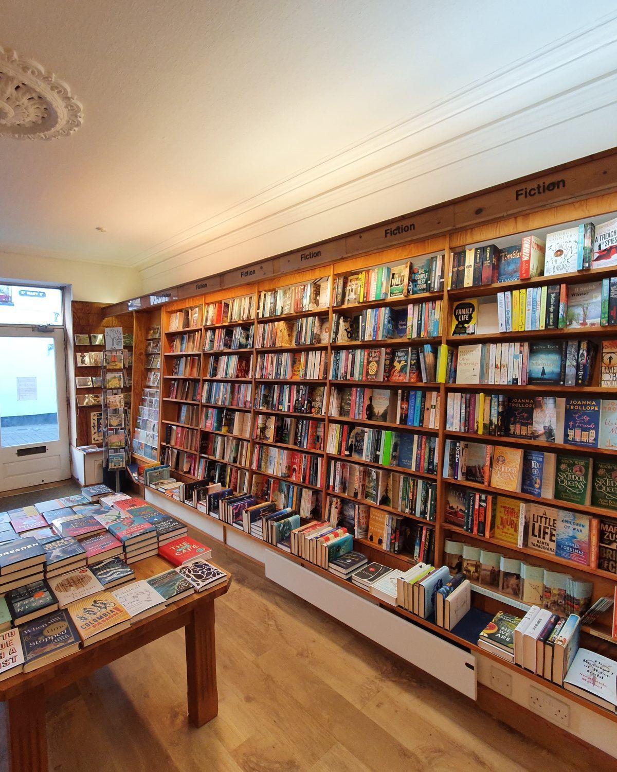 Inside Chepstow Books & Gifts: filled wooden shelves at 13 St Mary Street, Chepstow